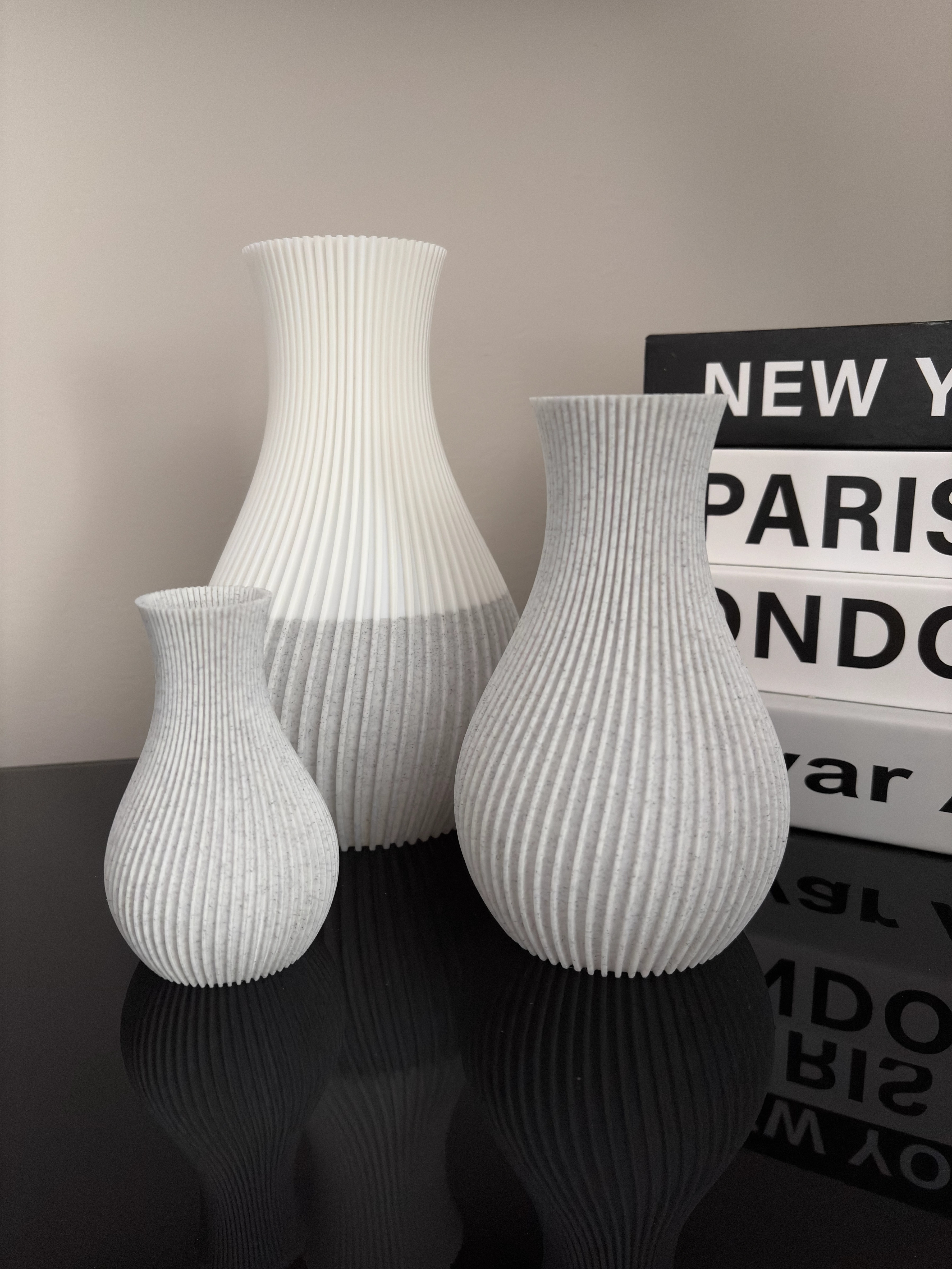Pleat vessels in small, medium and large sizes, with the large vessel shown in a custom white and marble split finish